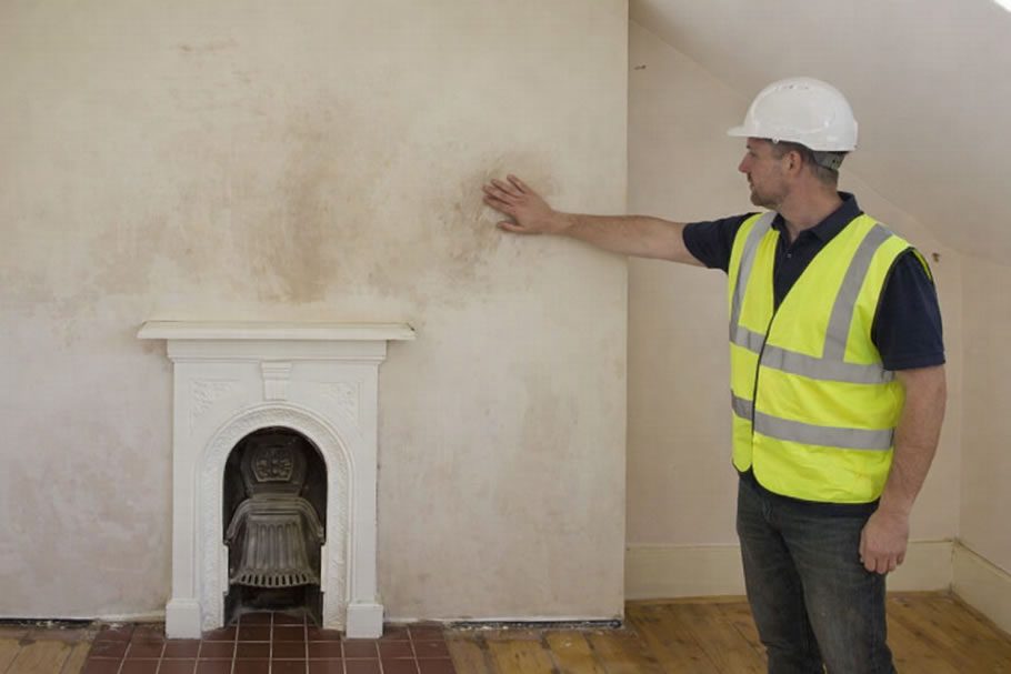 damp chimney breast - tradesman looking at problem area